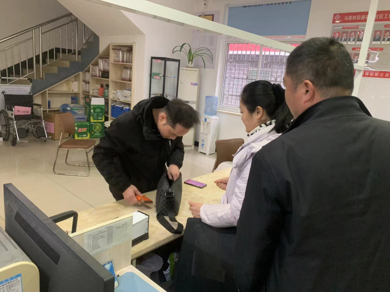 社区工作人员正陪同失主周先生查看包内物品。
