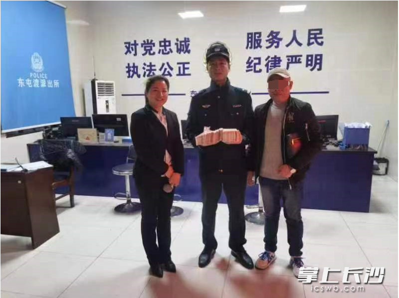 失主（右）在派出所拿回失物，左为拾金不昧的陈明新。受访者供图