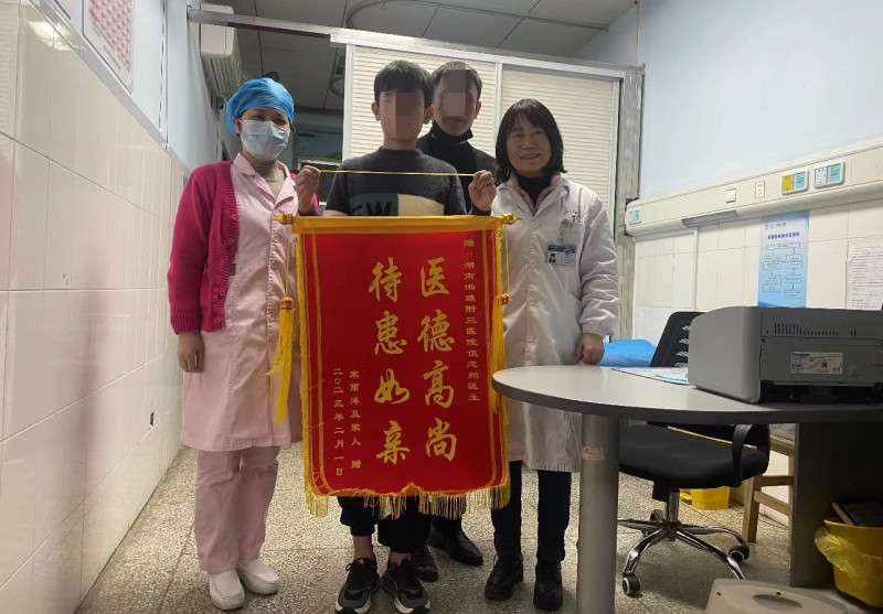 时隔12年后，为感谢当年的恩人，患者“宋可爱”一家给中南大学湘雅三医院儿科医生伍志翔送来锦旗。医院供图