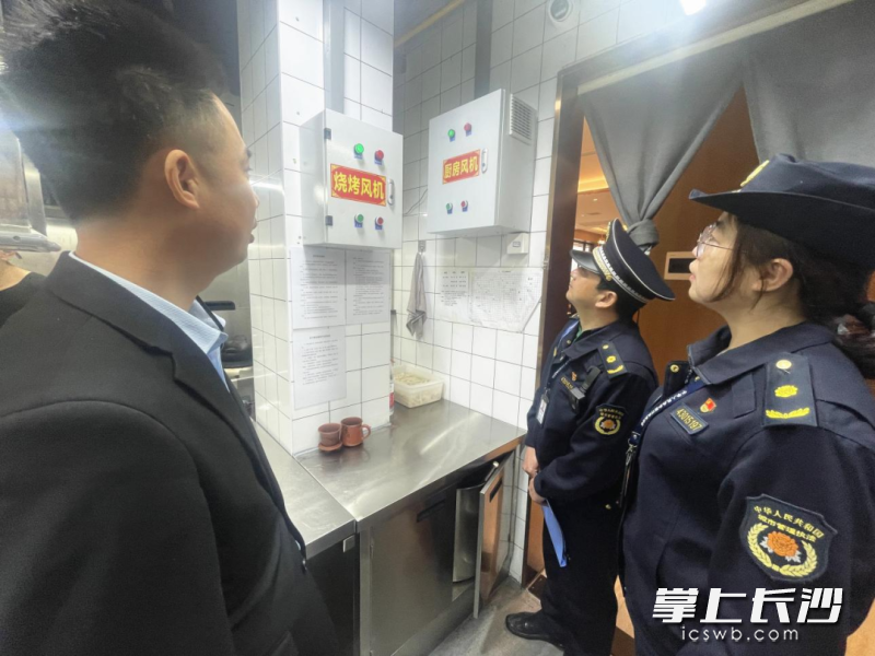 雨花区城管执法大队队员对辖区内的餐馆油烟净化器安装使用情况进行检查。