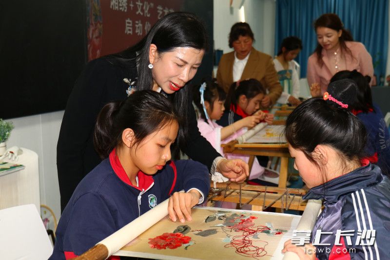 江再红手把手教学生制作湘绣作品。