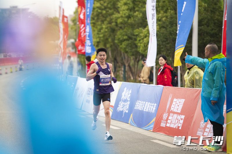 临近终点，工作人员竖起大拇指为参赛选手加油鼓劲。