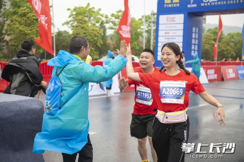 通过终点后，参赛选手兴奋地与工作人员击掌庆祝。