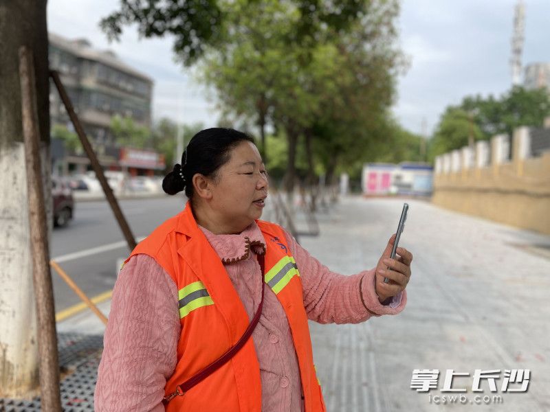 结束清扫工作后，莫桃云拿出手机开始唱歌，这是她的一种享受。长沙晚报全媒体记者 张洋子 摄