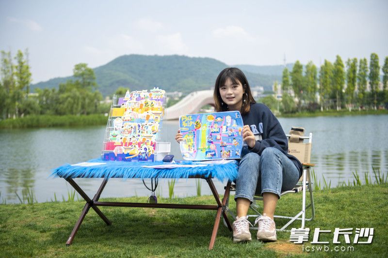 袁苗向游客展示由她创作的长沙Q版旅游攻略地图。均为长沙晚报全媒体记者 刘晓敏 郭雨滴 摄 袁苗向游客展示由她创作的长沙Q版旅游攻略地图。均为长沙晚报全媒体记者 刘晓敏 郭雨滴 摄