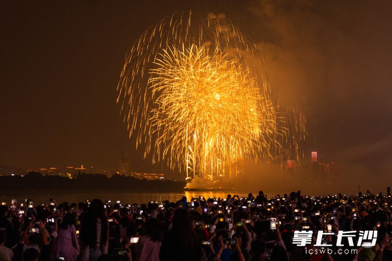 湘江风光带碧沙湖地铁站附近，观看烟花的市民和游客纷纷举起手机，拍摄烟花美景。