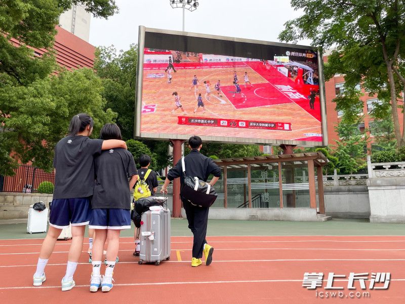 15日下午，雅礼女子篮球队返回学校后，队员们在操场上观看昨日精彩对局。长沙晚报全媒体记者 周数邑 摄