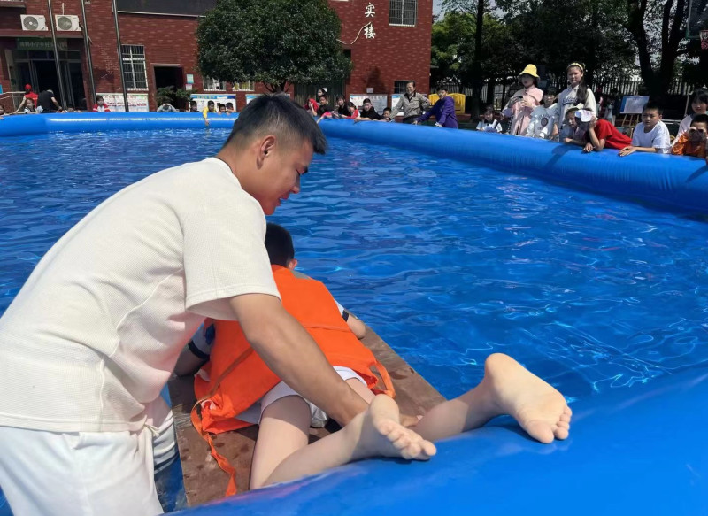 一名学生在老师的帮助下体验自制的“浮力船”。均为长沙晚报通讯员 李婵 吴雅菁 供图