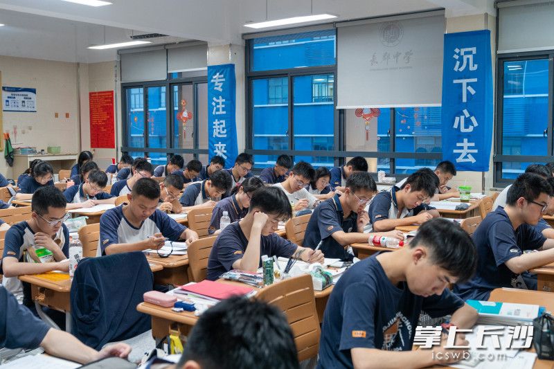 教室内挂满了励志向上的标语，标语下，高三学子们正积极备考。
