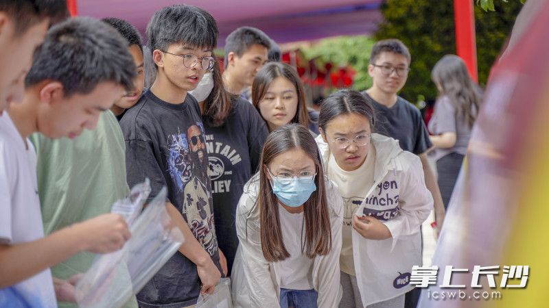 考生们依次查看自己所在考室的位置并进入考室熟悉位置。