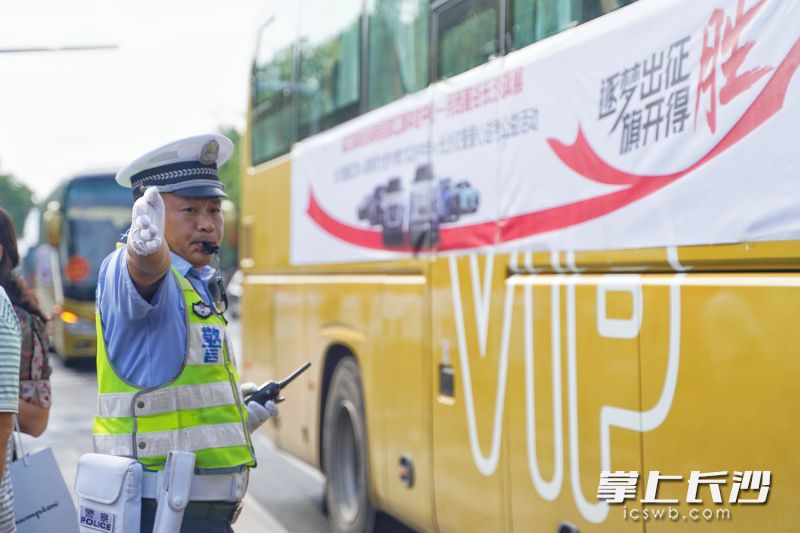 长沙交警岳麓大队民警为送考大巴交通引导。 
