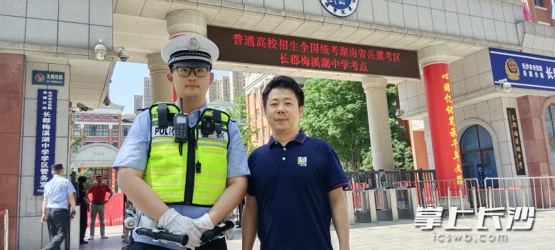 陈帅与初中班主任在校门口合影。