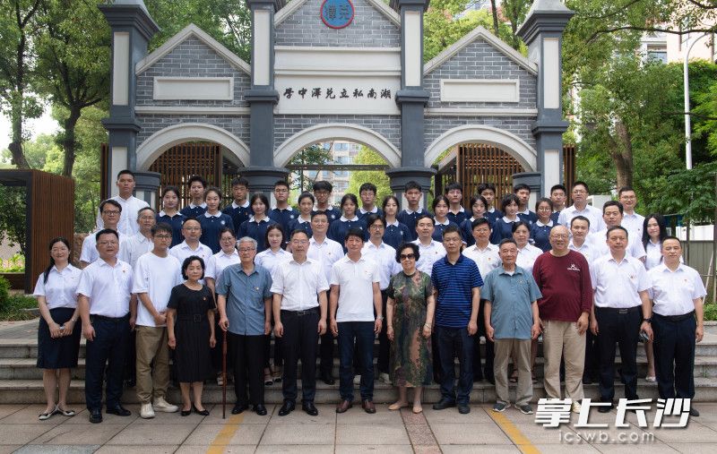 现场见证代表在老校门前合影纪念。