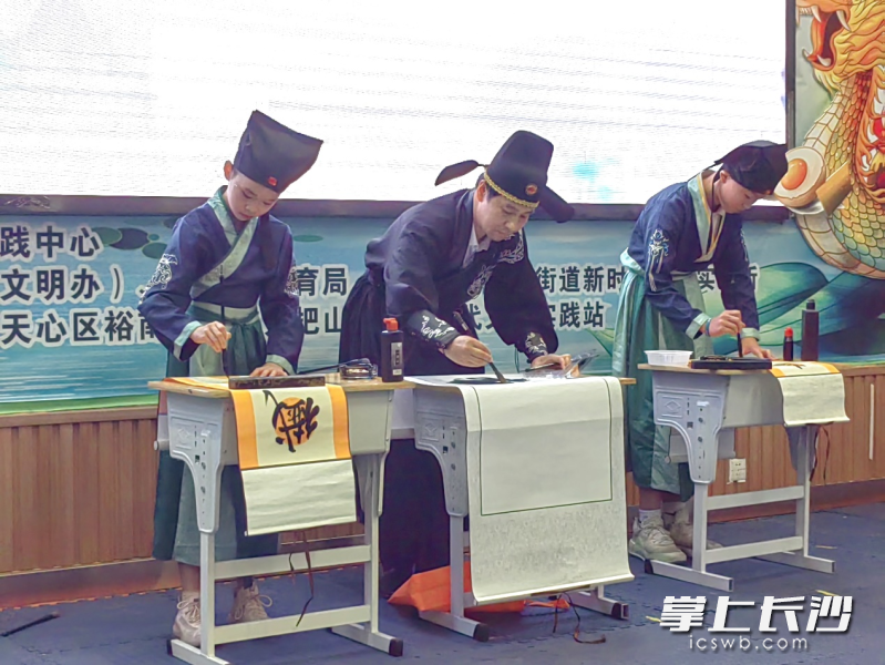 师生身着古装现场展示书法。