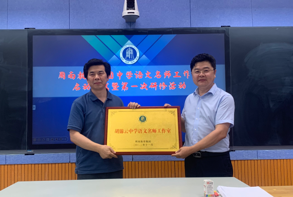 周南中学校长陈新春（右）为胡锦云中学语文名师工作室授牌。均为长沙晚报通讯员 薛群 供图