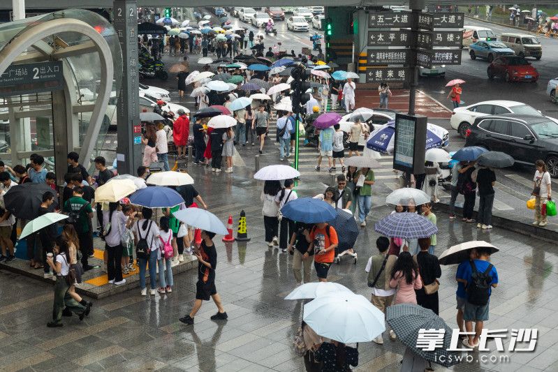 端午假期长沙迎来一波持续降雨，五一商圈游客携带雨具出行。均为长沙晚报全媒体记者 董阳 摄