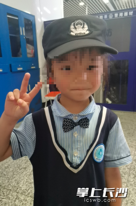 辅警让好奇的女孩戴着警帽。