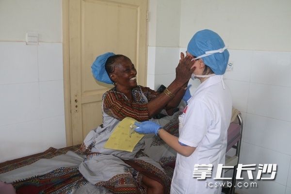 患者白内障手术重见光明，激动地抚摸主刀医生李芸的脸庞。