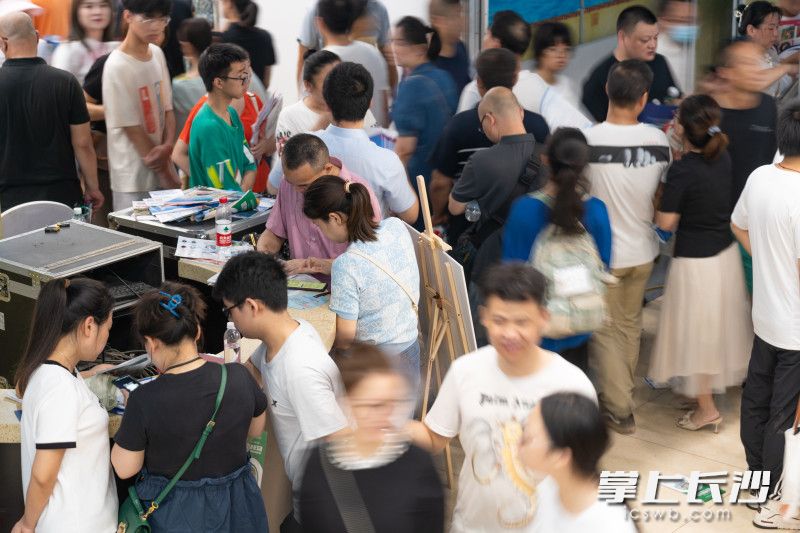 活动一角，不少家长闹中取静，正在安心整理招生信息。