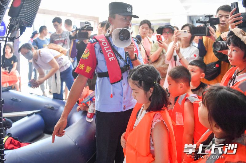 长沙市公安局治安支队水警大队水警正在给中小学生代表介绍水上救援装备。 