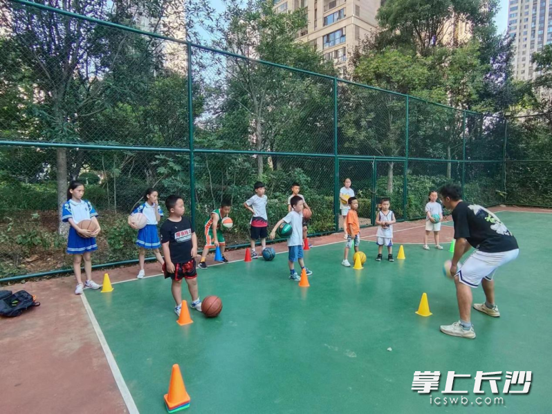 社区邀请篮球教练来小区篮球场给孩子们上公益篮球课。
