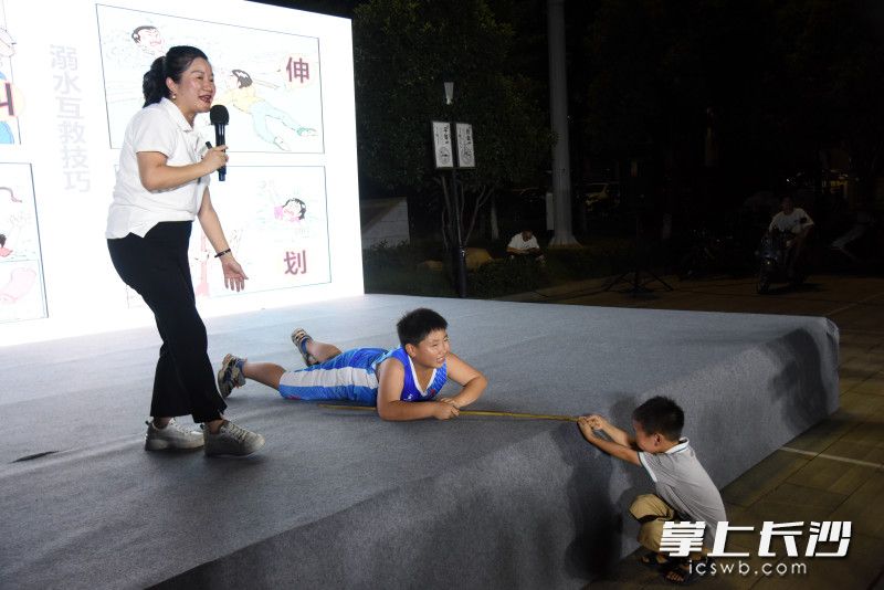 赖婷教孩子们如何用竹竿救助落水者。