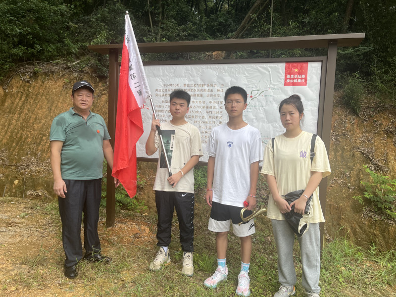 爱心公益人士吉付林（左一）给学生们深情讲述长征故事，带领他们“重走长征路”、厚植爱国情。
