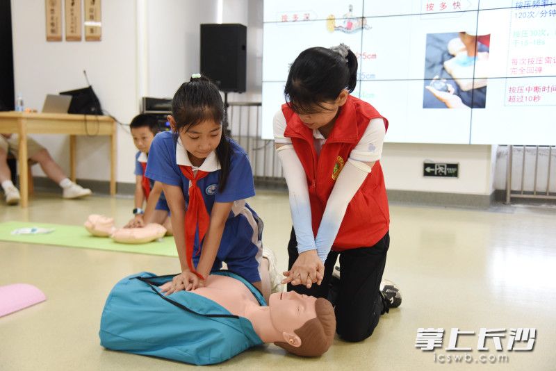 中南大学湘雅医院专家志愿者团队志愿者教孩子们学习心肺复苏术。