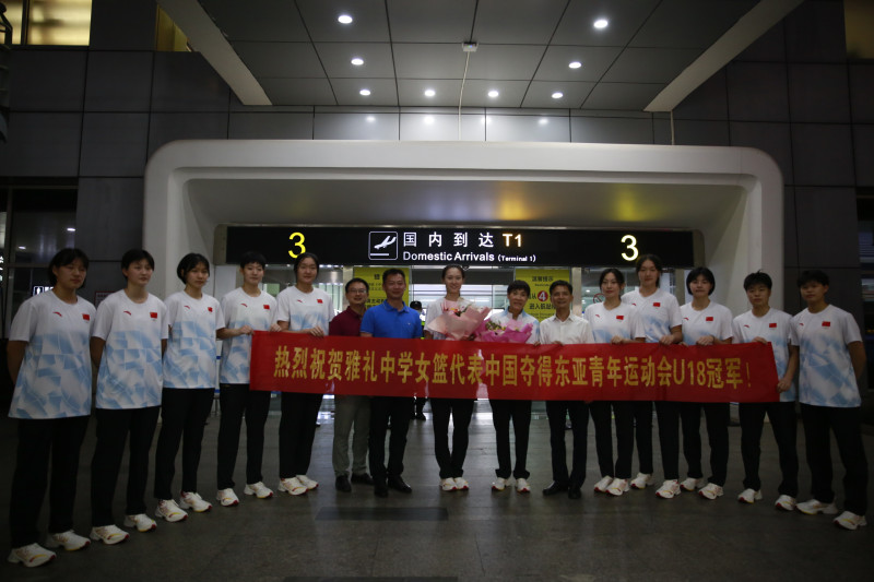 雅礼中学校长王旭（右六）等到机场迎接女篮队员。长沙晚报记者 冯启阳 通讯员 杨梦莹 摄影报道