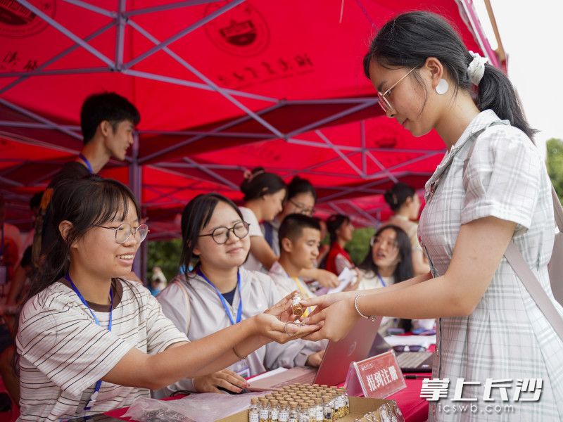 新生从学姐手中接过种子瓶。