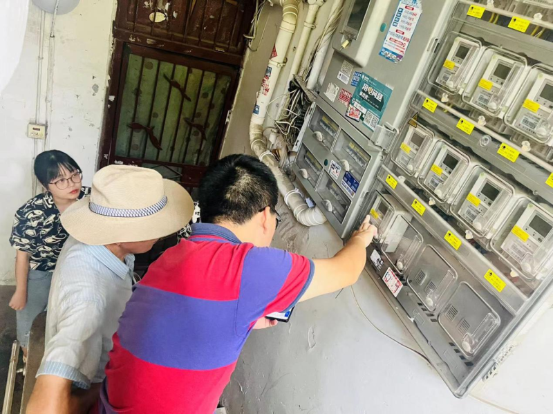 社区工作人员正在帮忙检查楼道灯。长沙晚报通讯员 彭汀汀 摄