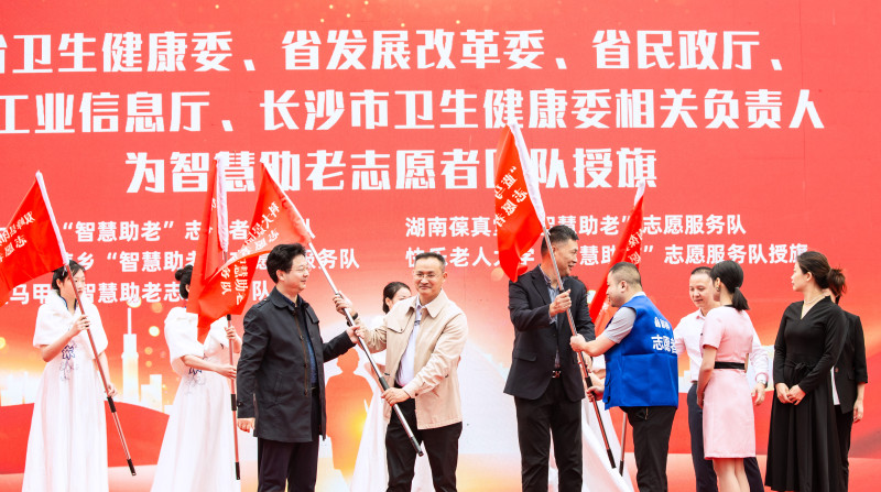省卫生健康委、省发展改革委、省工业和信息化厅、省民政厅相关负责人为“智慧助老”志愿者团队授旗。