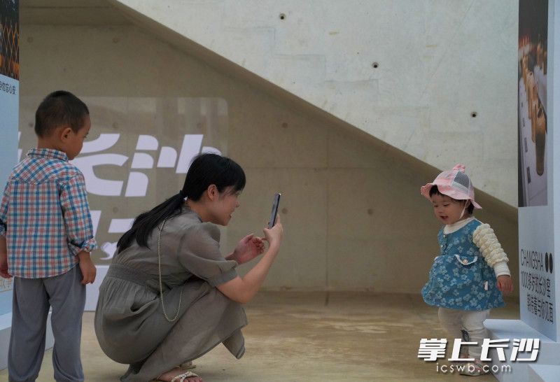 “100个爱长沙的理由”展厅中，妈妈给孩子拍照留念。均为长沙晚报全媒体记者 何文瑞 摄