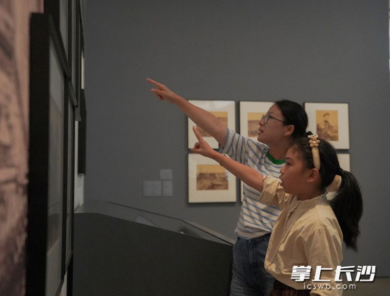 妈妈给女儿讲解展品相关知识。