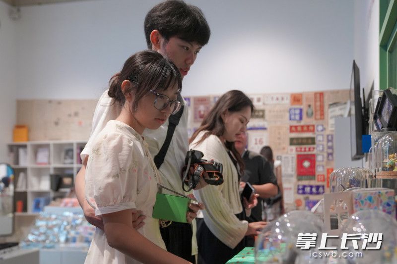 游客挑选纪念商品。