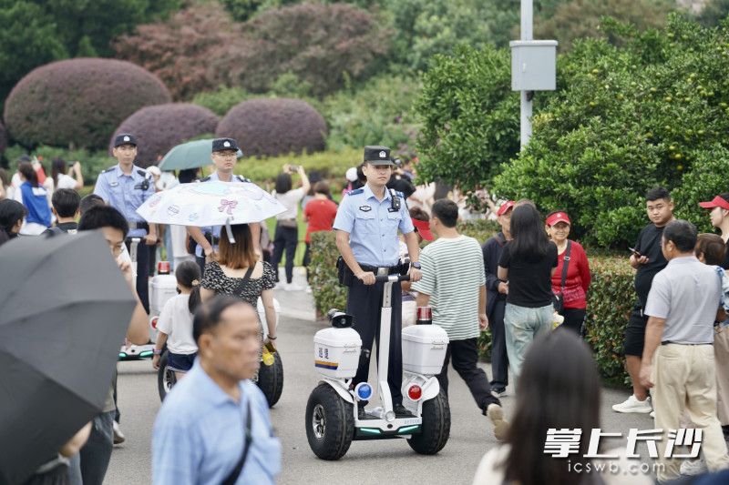警务人员骑着警用平衡车，在橘子洲景区巡逻，站得相对更高视野更开阔，更易在人群中发现异常情况。 长沙晚报全媒体记者 周数邑 罗亚坤 摄