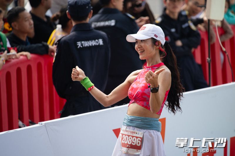 在比赛全程项目终点，一位女选手在庆祝完赛。