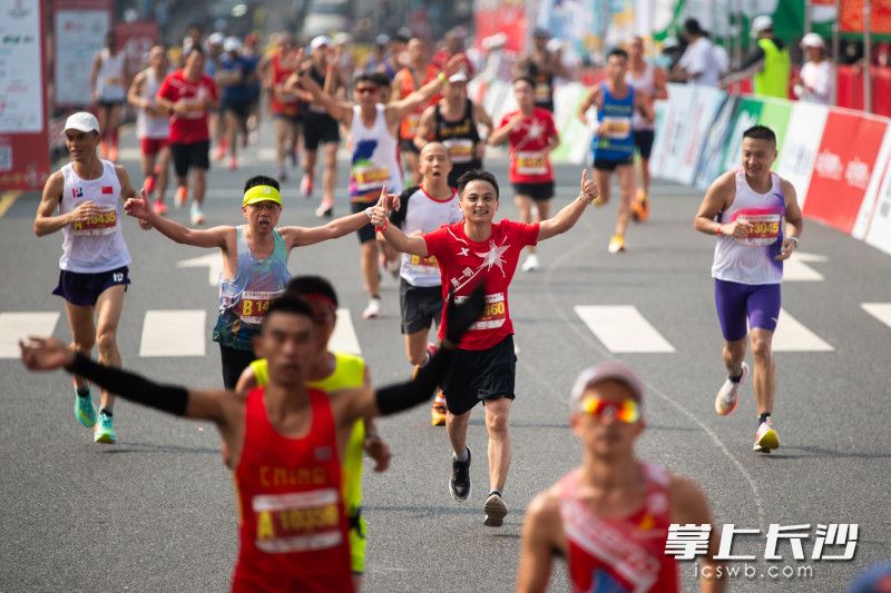 在全程项目比赛终点，选手们纷纷竖起大拇指在庆祝。