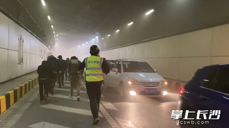 演练中，工作人员正在疏散事故隧道内人员，引导大家迅速前往逃生通道。