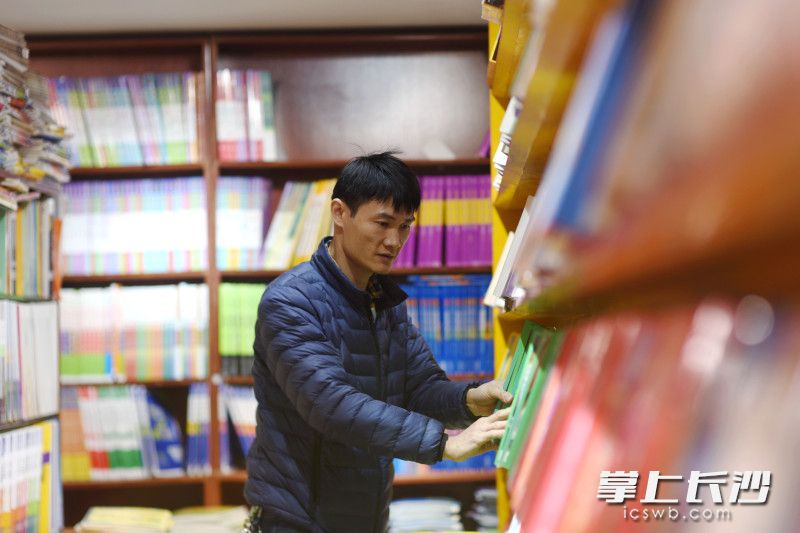 李波正在整理书架上的书，这家小书店将会继续留下来。均为长沙晚报全媒体记者 刘琦 摄