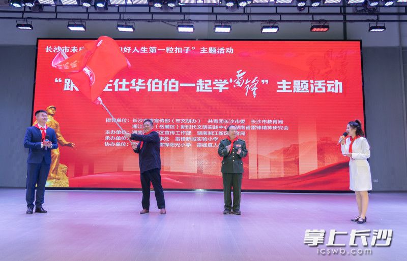 庄仕华（右二）将“当代雷锋庄仕华志愿者服务团长沙分团”团旗授予团长欧阳华初（左二）。