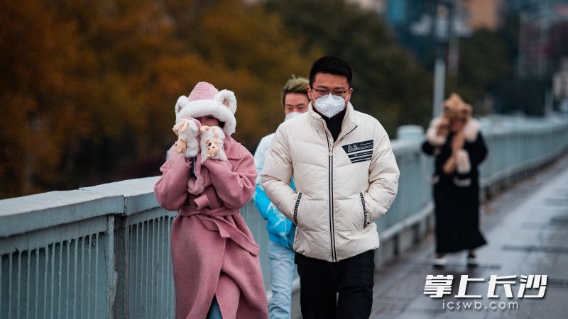 几位市民在橘子洲大桥上冒着寒风出行，寒意浓浓。均为长沙晚报全媒体记者 邹麟 摄