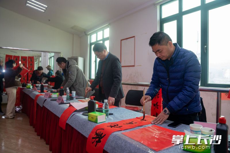 活动现场，书法艺术家为社区群众现场写春联、送“福”字。