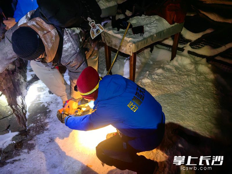现场，岳麓蓝天救援队队员为被困大学生鞋子上装好冰爪。均为受访者供图