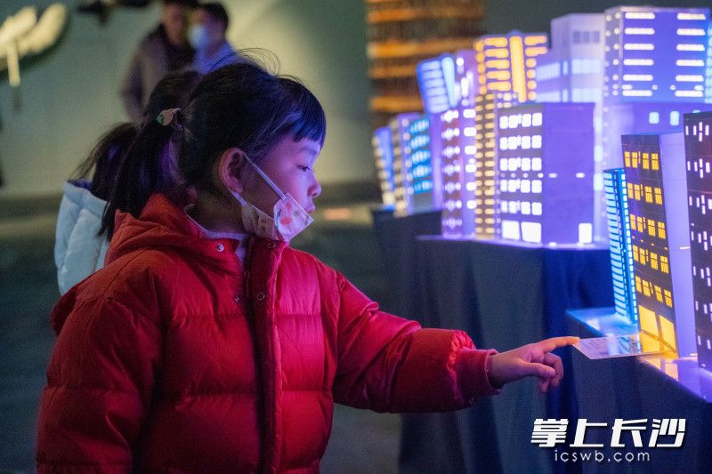 一名小女孩正在与会动的荧光楼宇互动。 一名小女孩正在与会动的荧光楼宇互动。