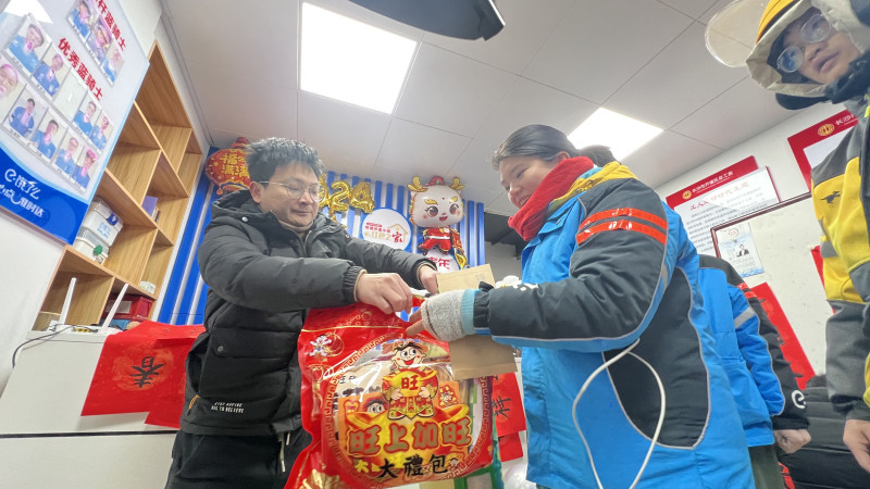 外卖骑手领到新年礼物。长沙晚报全媒体记者 周辉霞 摄
