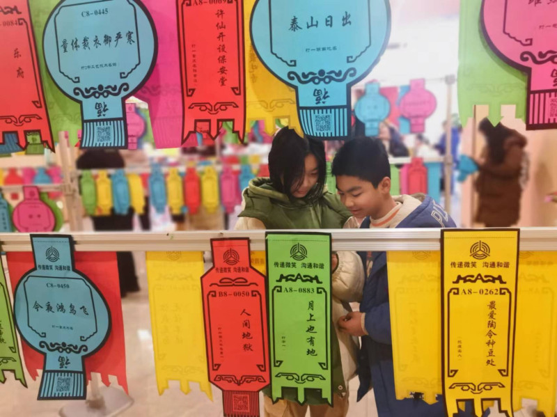 大小朋友正在聚精会神猜灯谜。均为长沙晚报全媒体记者 颜家文 摄