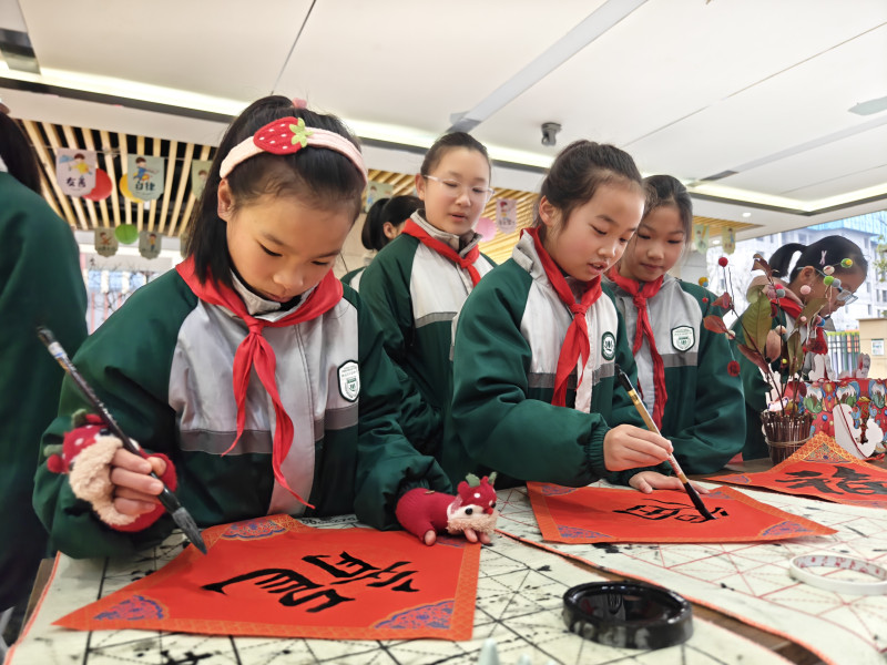孩子们用毛笔写下“福”或“龙”字。