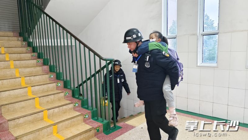 两位保安轮流接力背着女孩上楼。