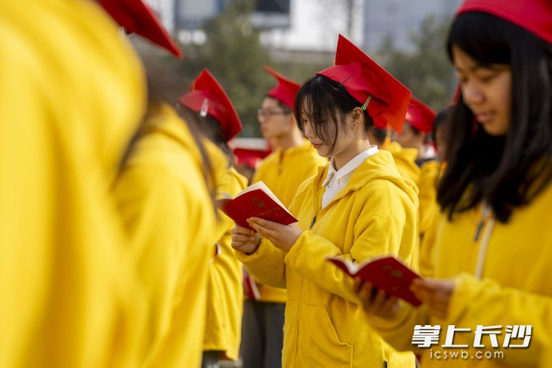 同学们在认真阅读《中华人民共和国宪法》，铭记责任、肩负责任、践行责任。